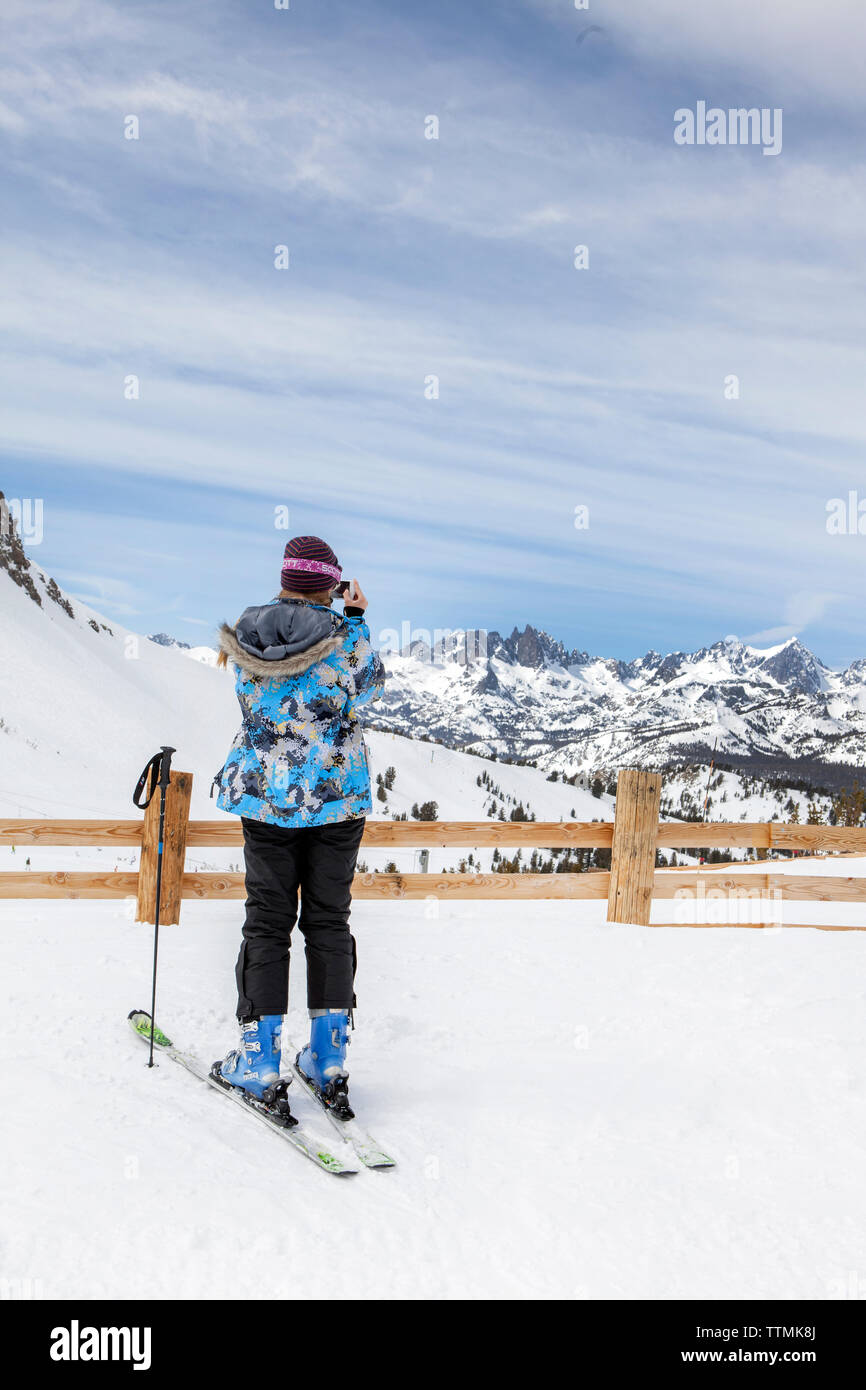 California, Estados Unidos, Mammoth, un esquiador femenino toma un descanso para hacer una foto de los cautivadores paisajes en Mammoth Ski Resort Foto de stock