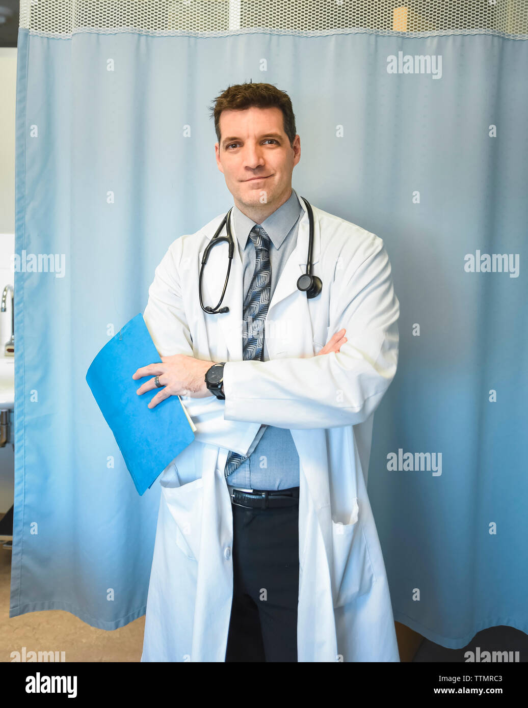 Doctor en bata blanca de pie en frente de la habitación de hospital de la cortina. Foto de stock
