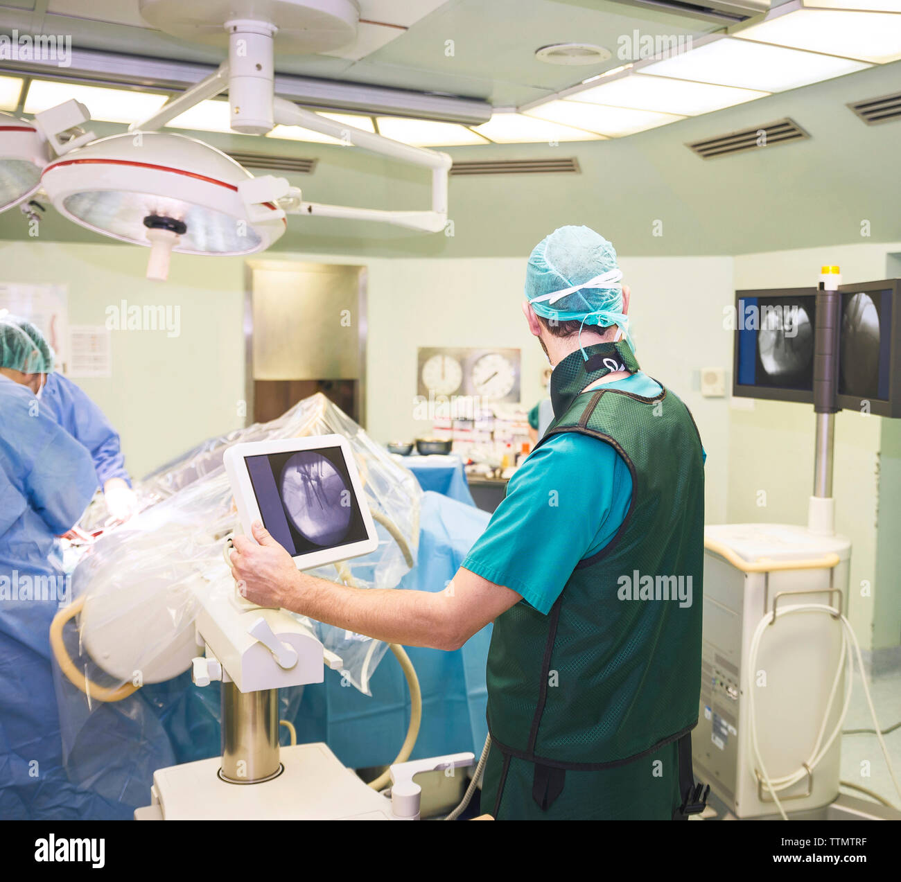 Vista trasera del cirujano con compañeros de trabajo en el quirófano Foto de stock
