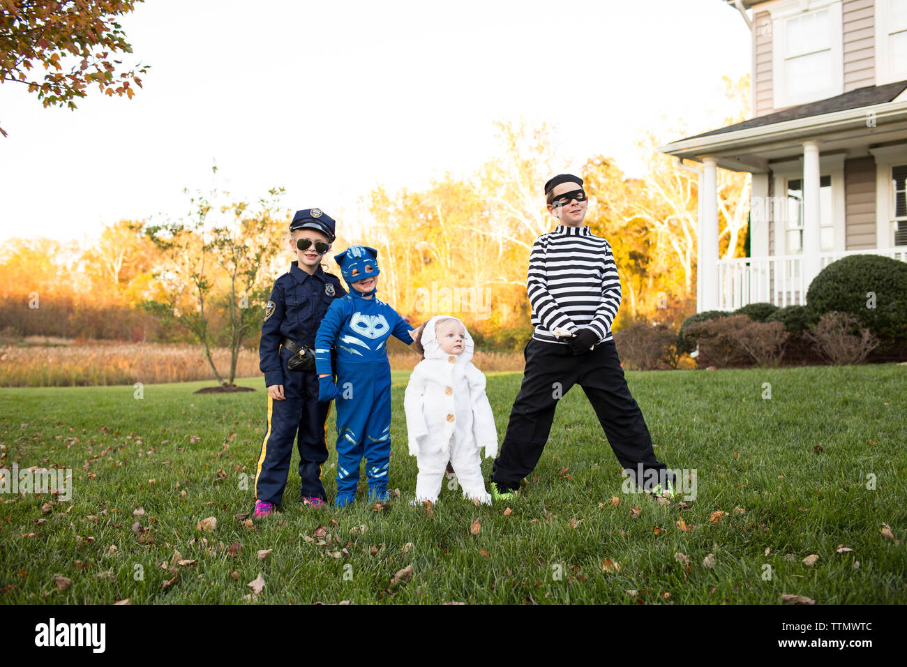 Cuatro hermanos en disfraces de Halloween en la parte frontal de la casa al  atardecer Fotografía de stock - Alamy