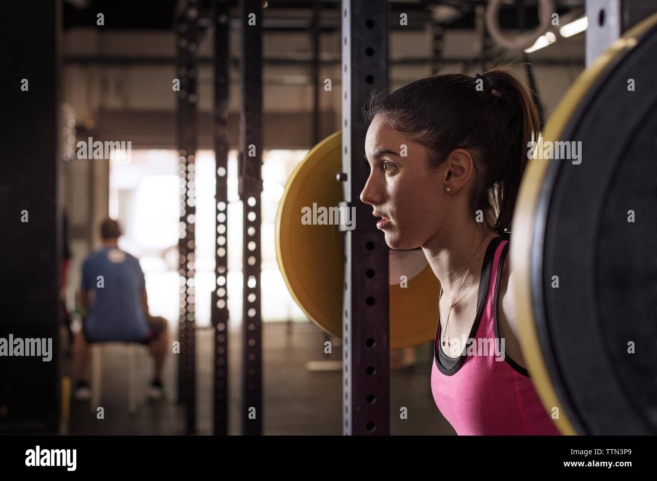 Elevación de la atleta femenina determinada barbell en club de salud Foto de stock