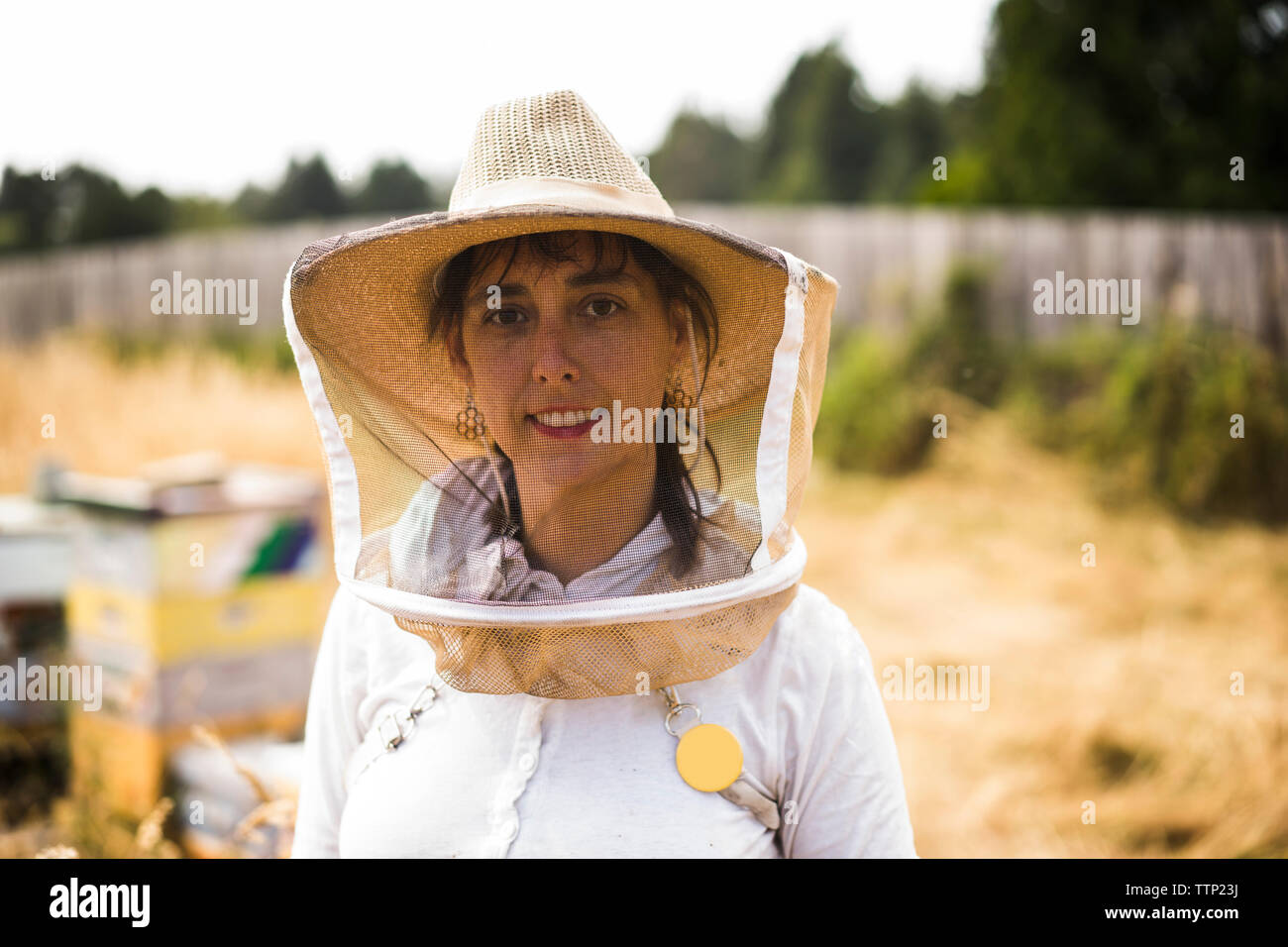 Retrato de mujer vistiendo apicultor máscara protectora y sombrero en el campo Foto de stock