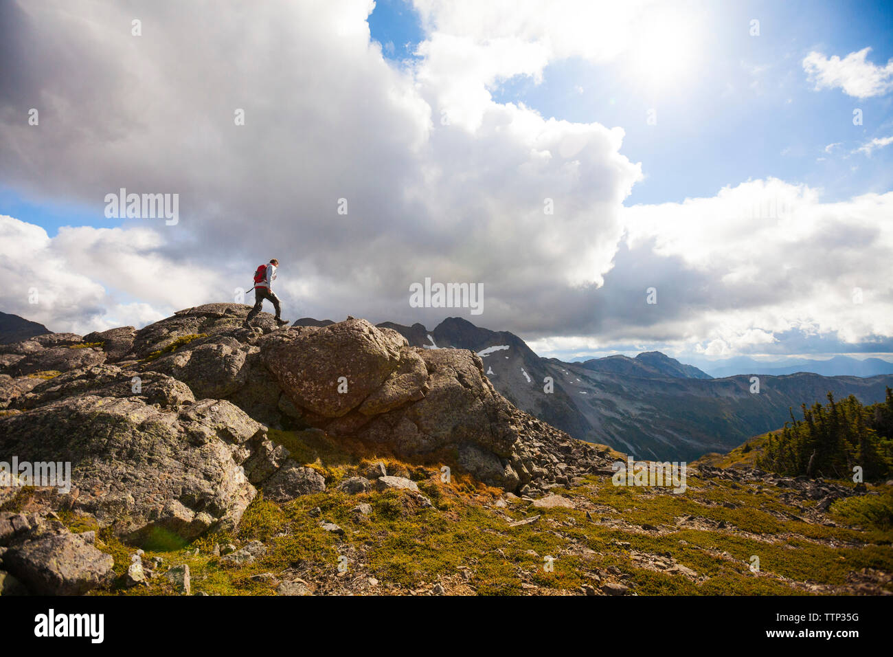 Caminante la escalada en las rocas contra el cielo nublado Foto de stock