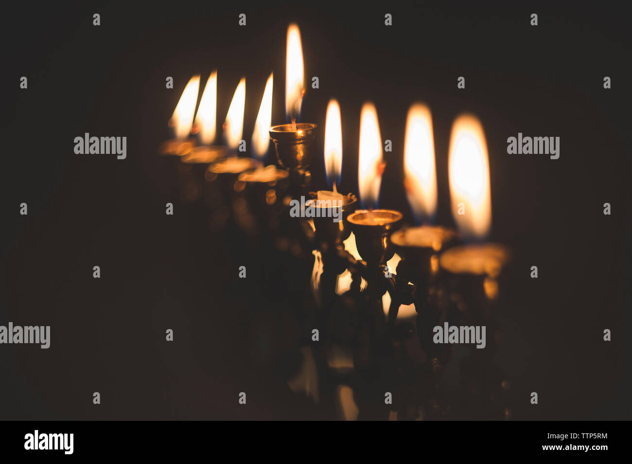 Close-up de velas brillando en cuarto oscuro Foto de stock