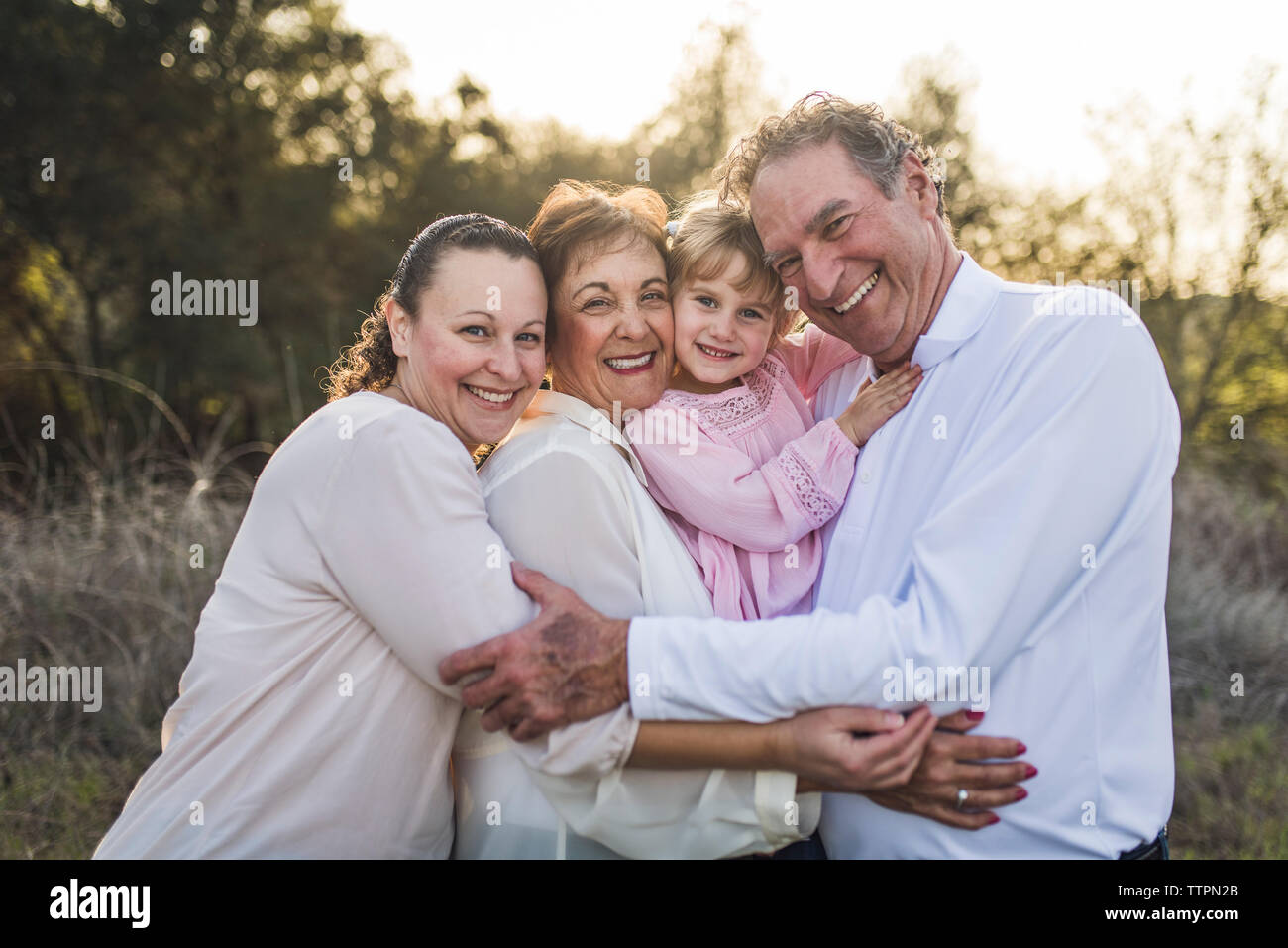 Familia multigeneracionales abrazar en el campo Foto de stock