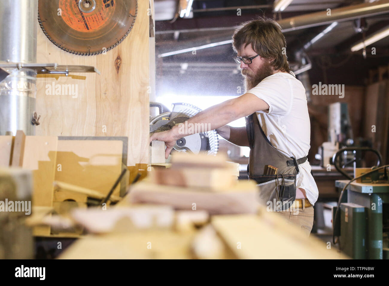 Carpenter usando una sierra circular en el taller Foto de stock