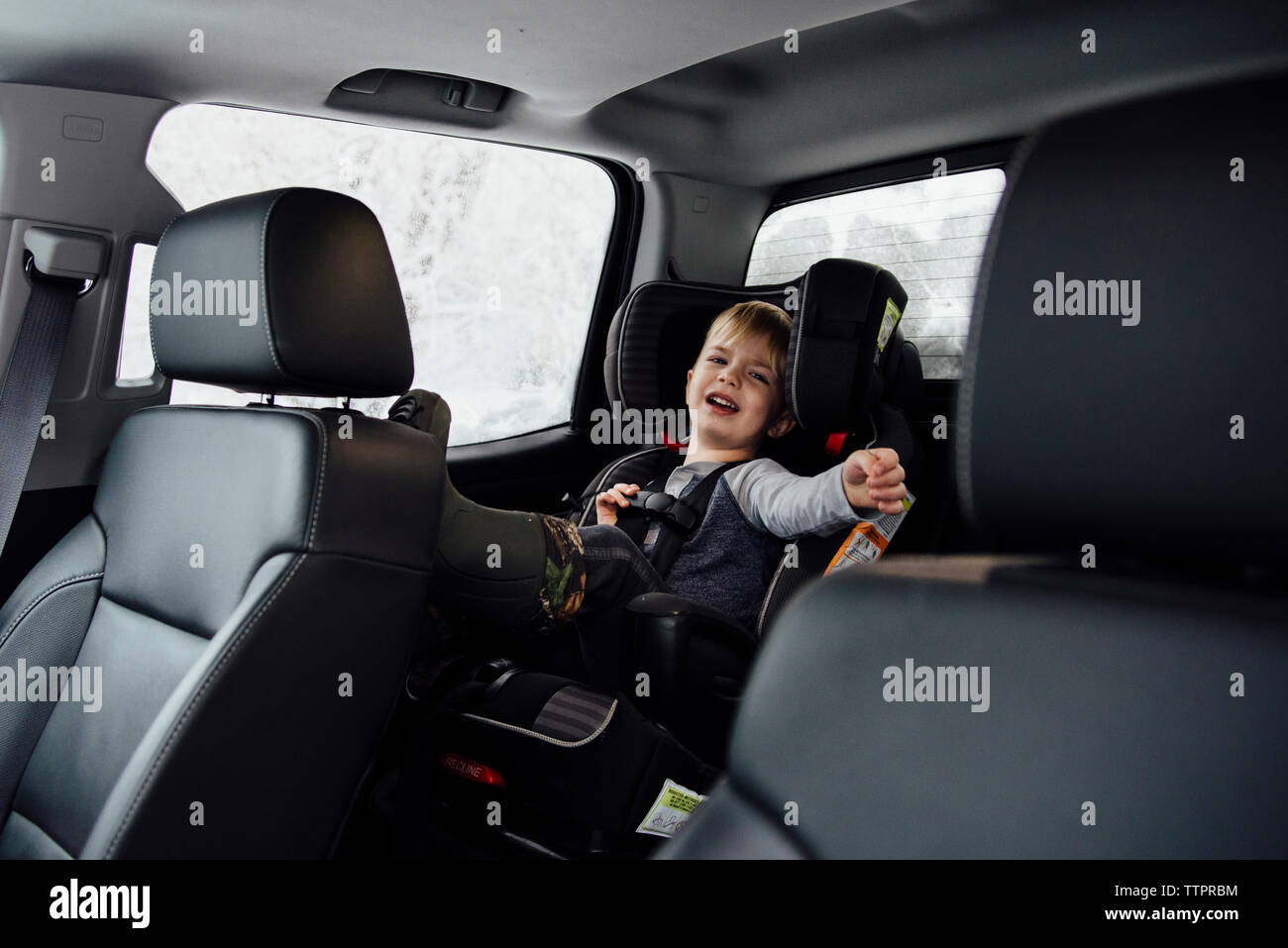 Retrato de niño llorando mientras está sentado en el asiento del vehículo. Foto de stock