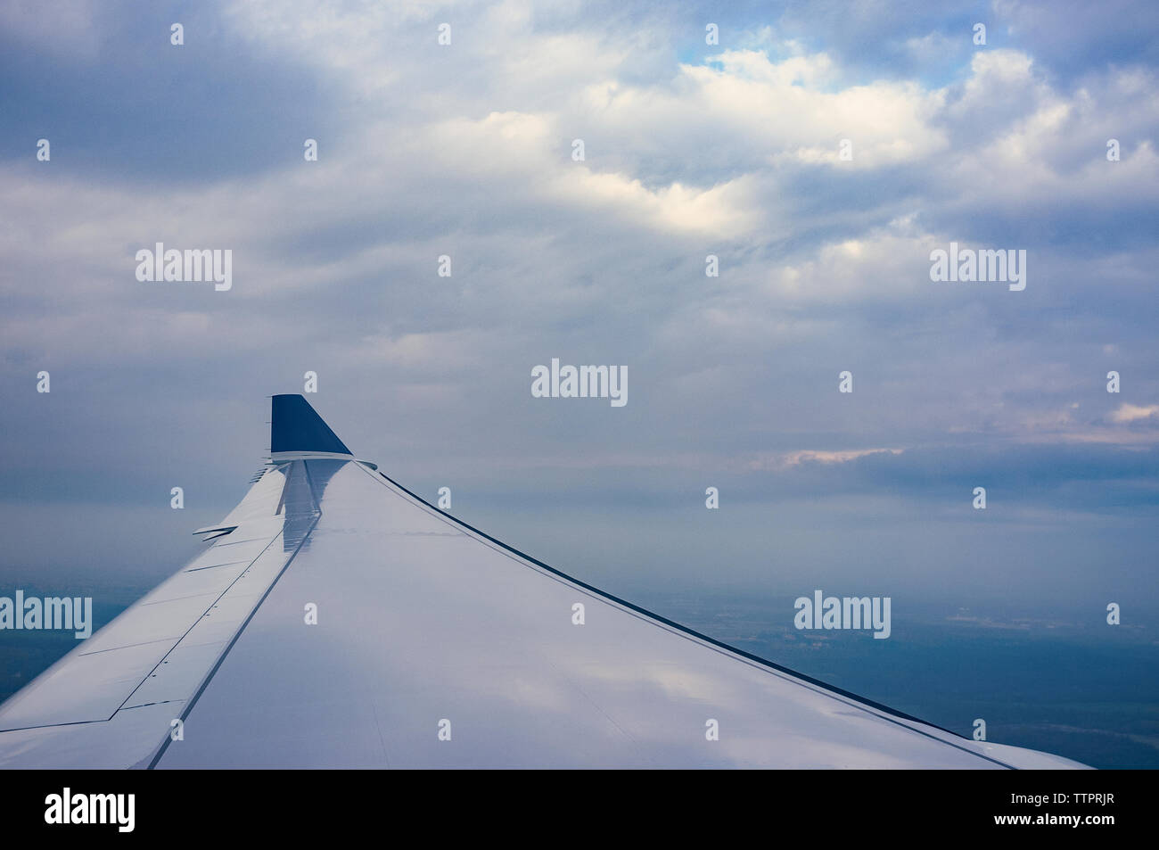 Imagen recortada del avión volando contra el cielo nublado Foto de stock
