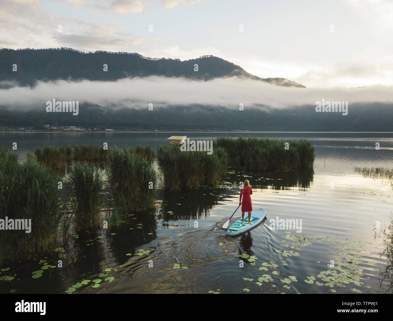 Una mujer sobre un lago paddleboarding Foto de stock