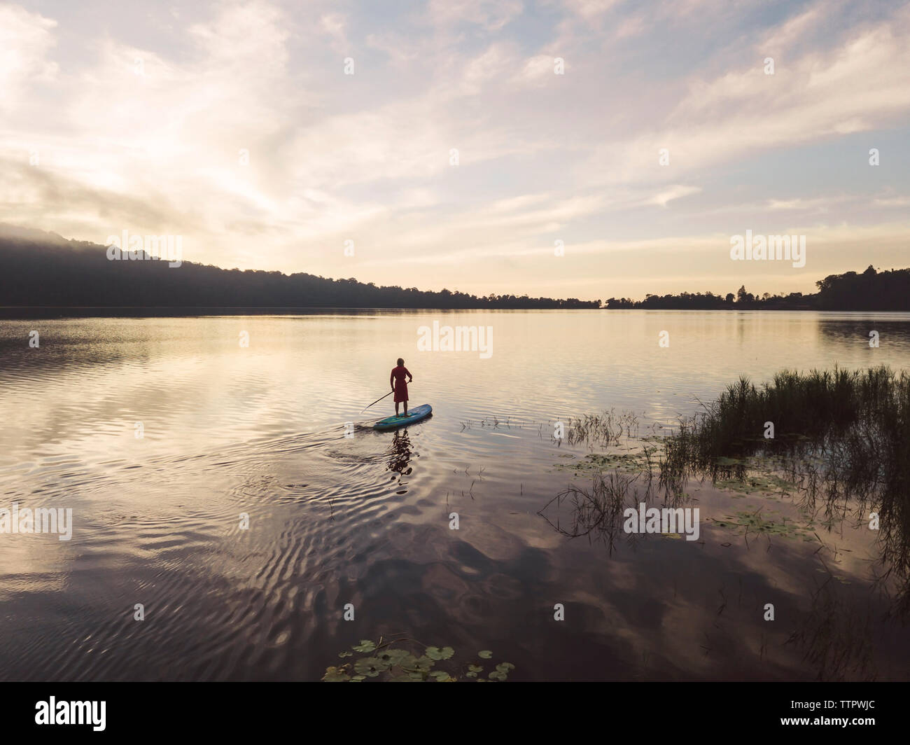Una mujer sobre un lago paddleboarding Foto de stock