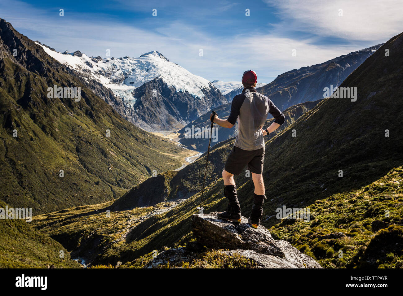 Trekker con vistas a las montañas y el valle alpino en Nueva Zelanda Foto de stock