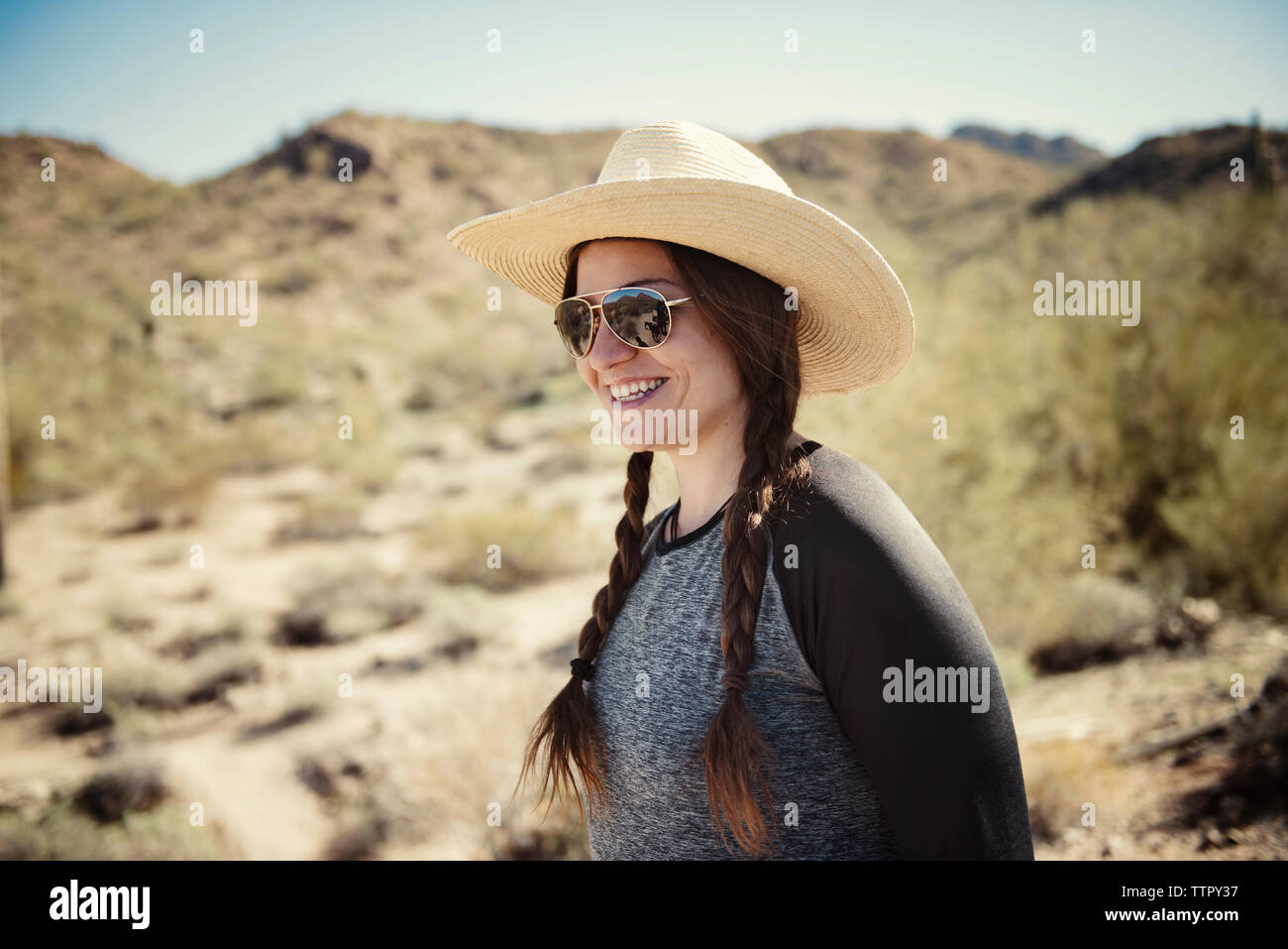 Feliz mujer vistiendo sombrero para el sol de pie en la montaña durante los  meses de verano Fotografía de stock - Alamy