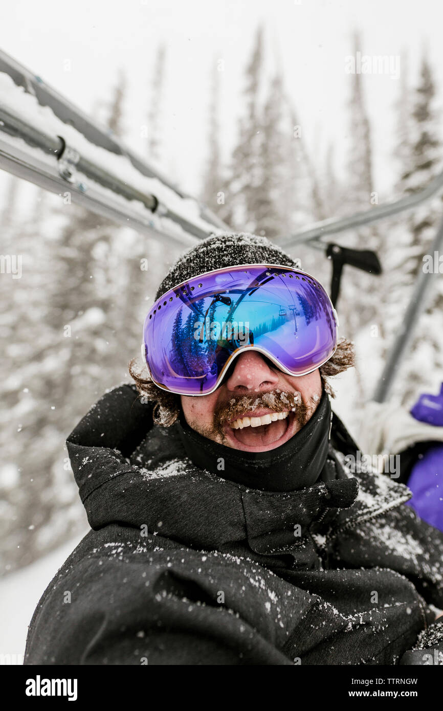 Niña sentada en la nieve llevaba gafas de esquí Fotografía de stock - Alamy