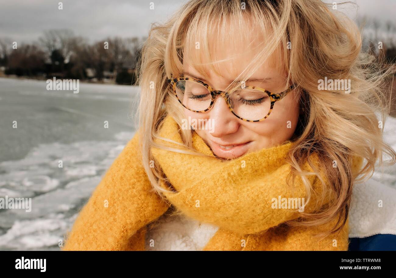 Retrato de mujer rubia con gafas sonriendo mientras en la playa. Foto de stock