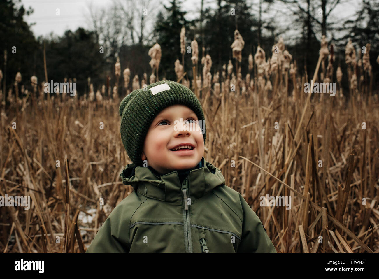 Joven sonriente, retrato de muchacho en invierno Gorra y escudo Foto de stock
