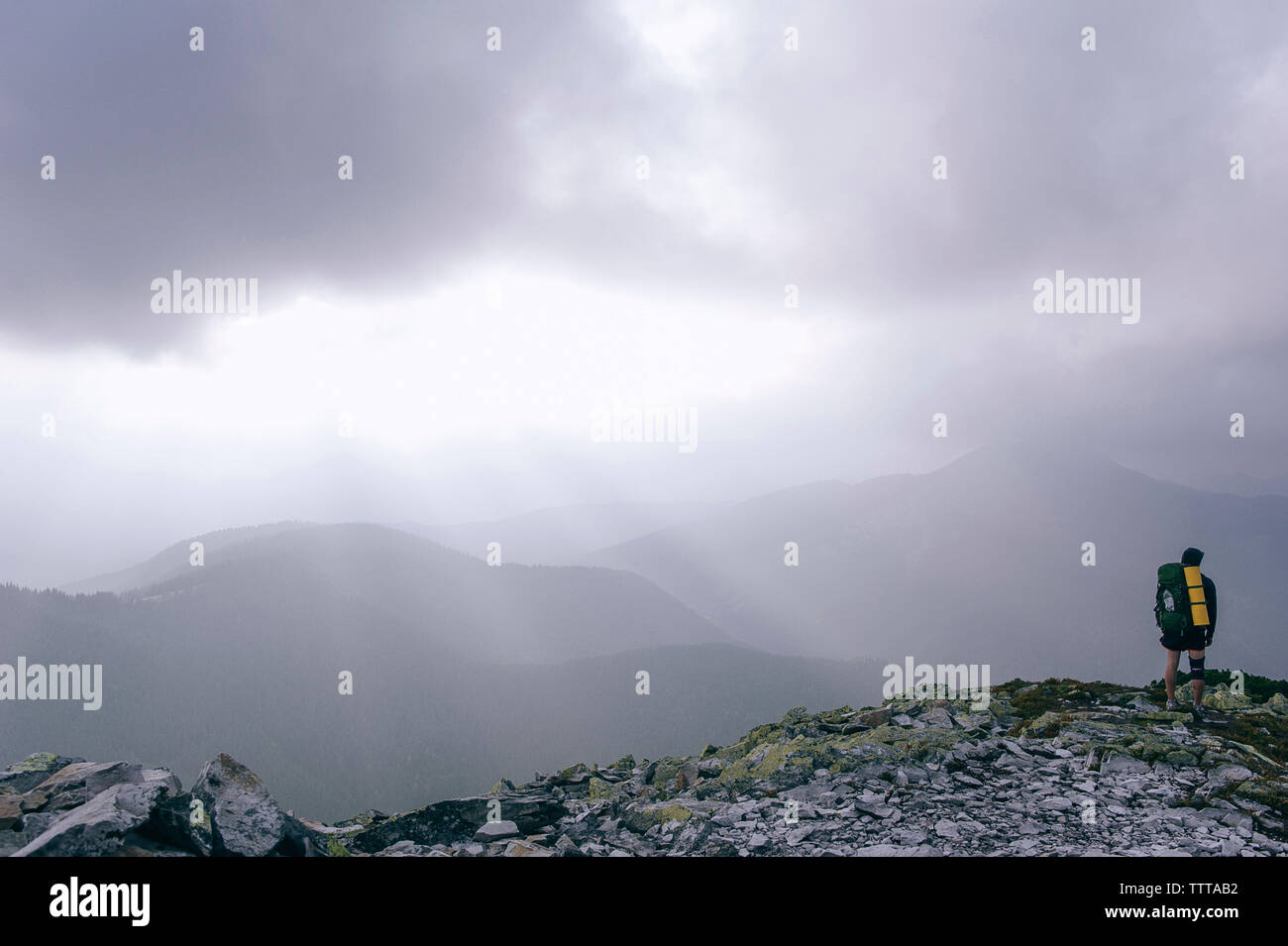 La longitud total del excursionista de montaña permanente durante la niebla Foto de stock