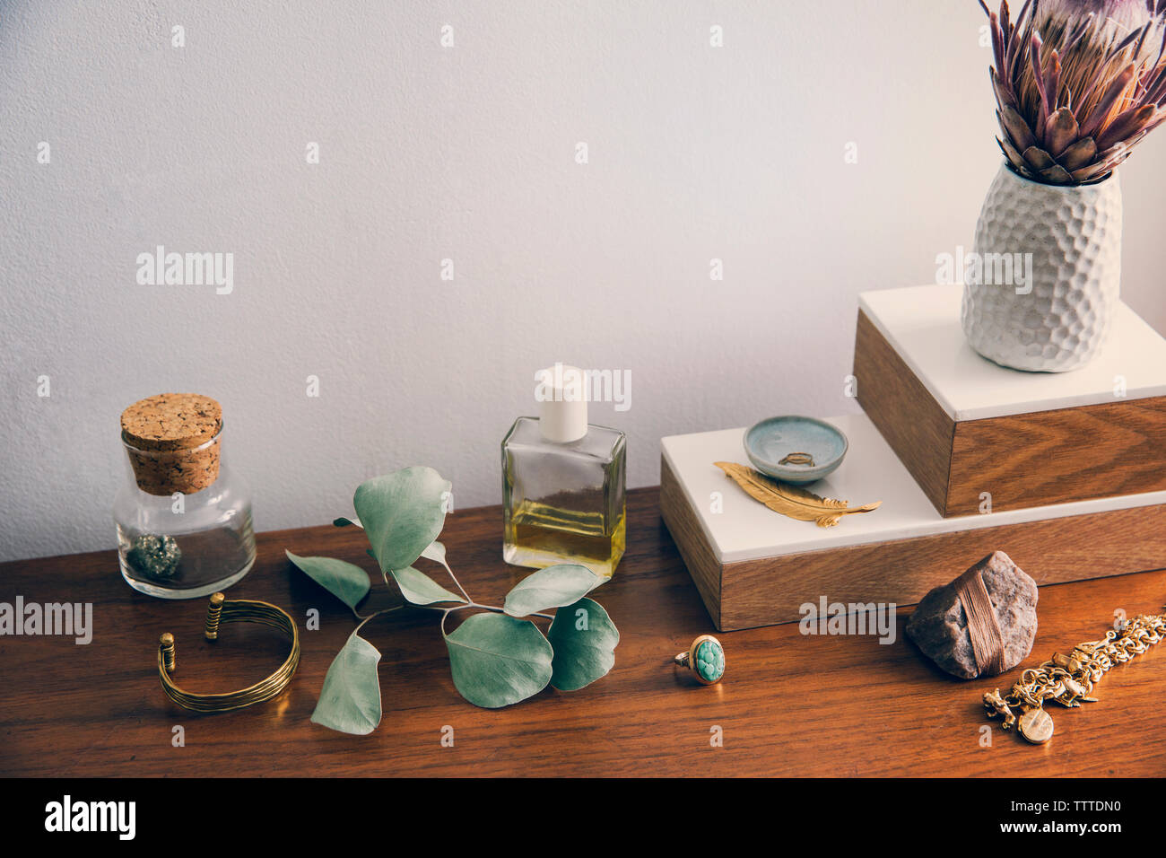 Un alto ángulo de visualización del florero con joyas y productos de belleza en la tabla Foto de stock