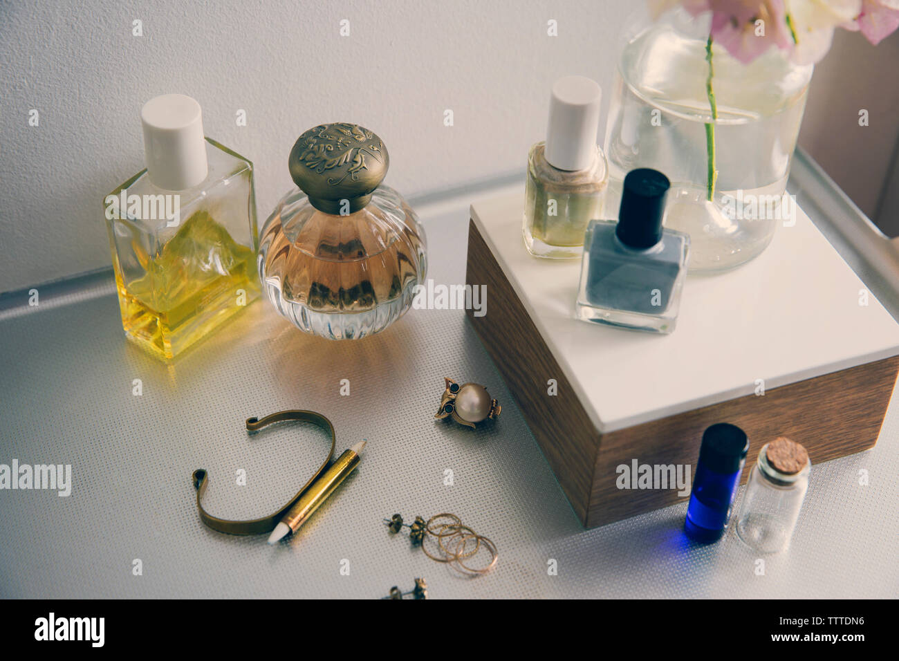 Un alto ángulo de visualización de productos de belleza con joyas en la mesa Foto de stock
