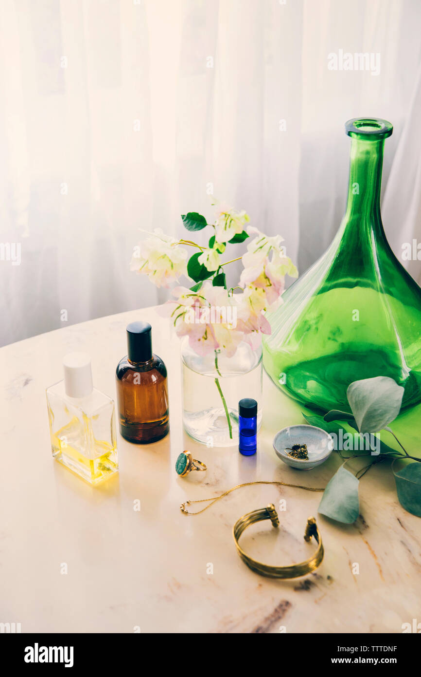 Un alto ángulo de visualización de productos de belleza y joyas de florero en la mesa Foto de stock
