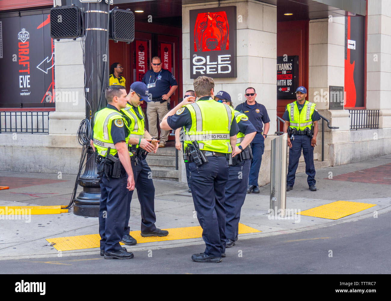 Los funcionarios encargados de hacer cumplir la ley de la policía de pie y hablando en Broadway en el NFL Draft 2019 de Nashville, Tennessee, EE.UU.. Foto de stock