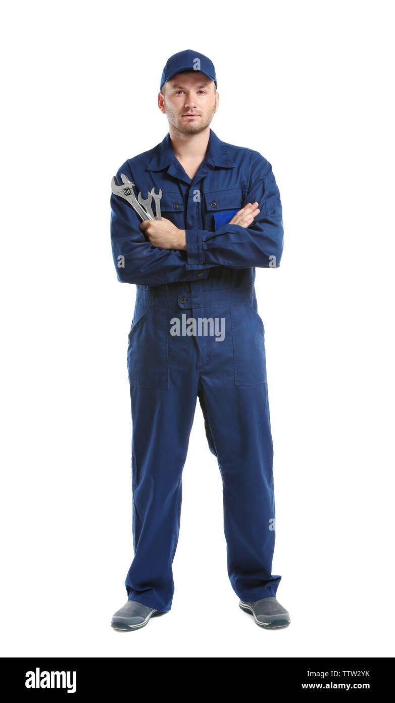 Joven mecánico en uniforme de brazos cruzados y llaves de pie, aislado en  blanco Fotografía de stock - Alamy