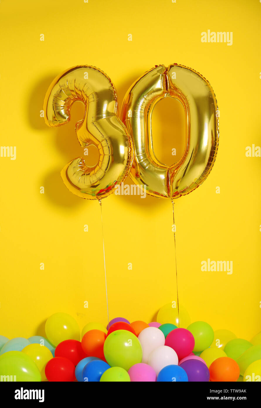 Los globos de oro para la celebración del 30 cumpleaños de fondo de pared  amarilla Fotografía de stock - Alamy