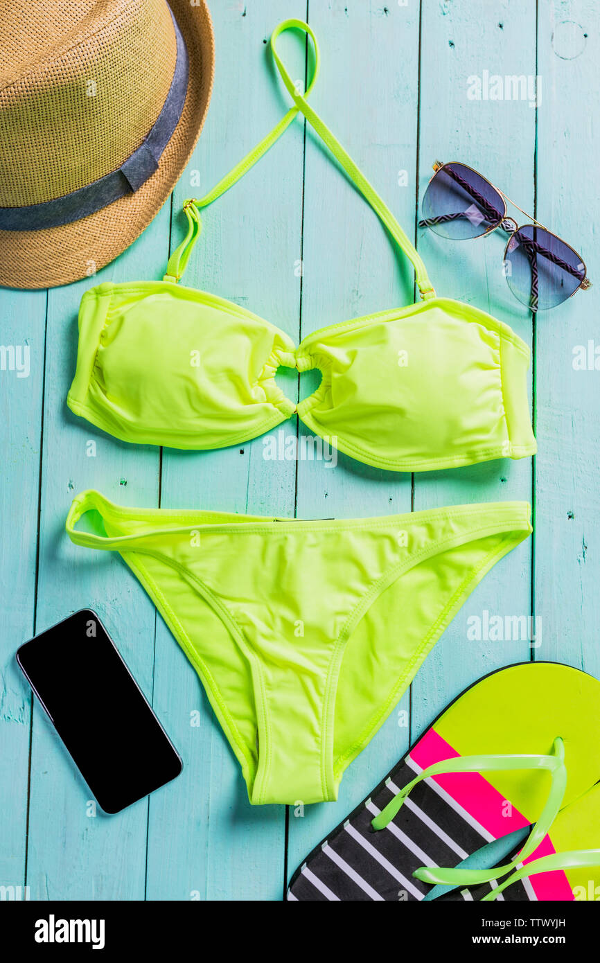 Accesorios de playa con amarillo traje de baño, gafas de sol y chanclas Foto de stock
