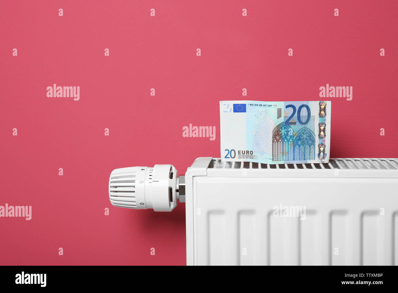 Concepto de ahorro. Dinero y radiador de calefacción con regulador de  temperatura, sobre fondo de color rosa Fotografía de stock - Alamy
