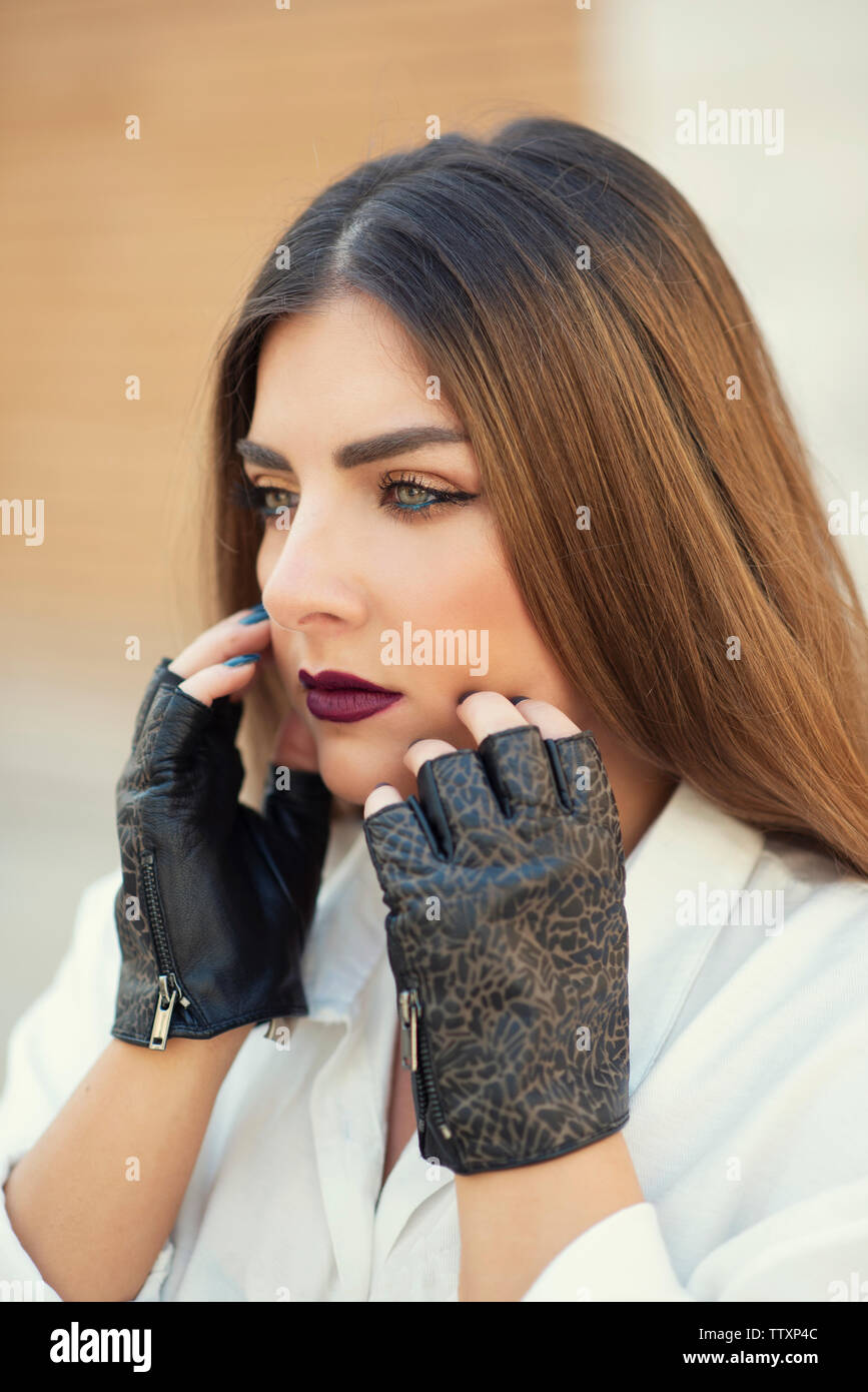 Hermosa mujer vistiendo sin dedos guantes de cuero manos tocan mirando  lejos Fotografía de stock - Alamy