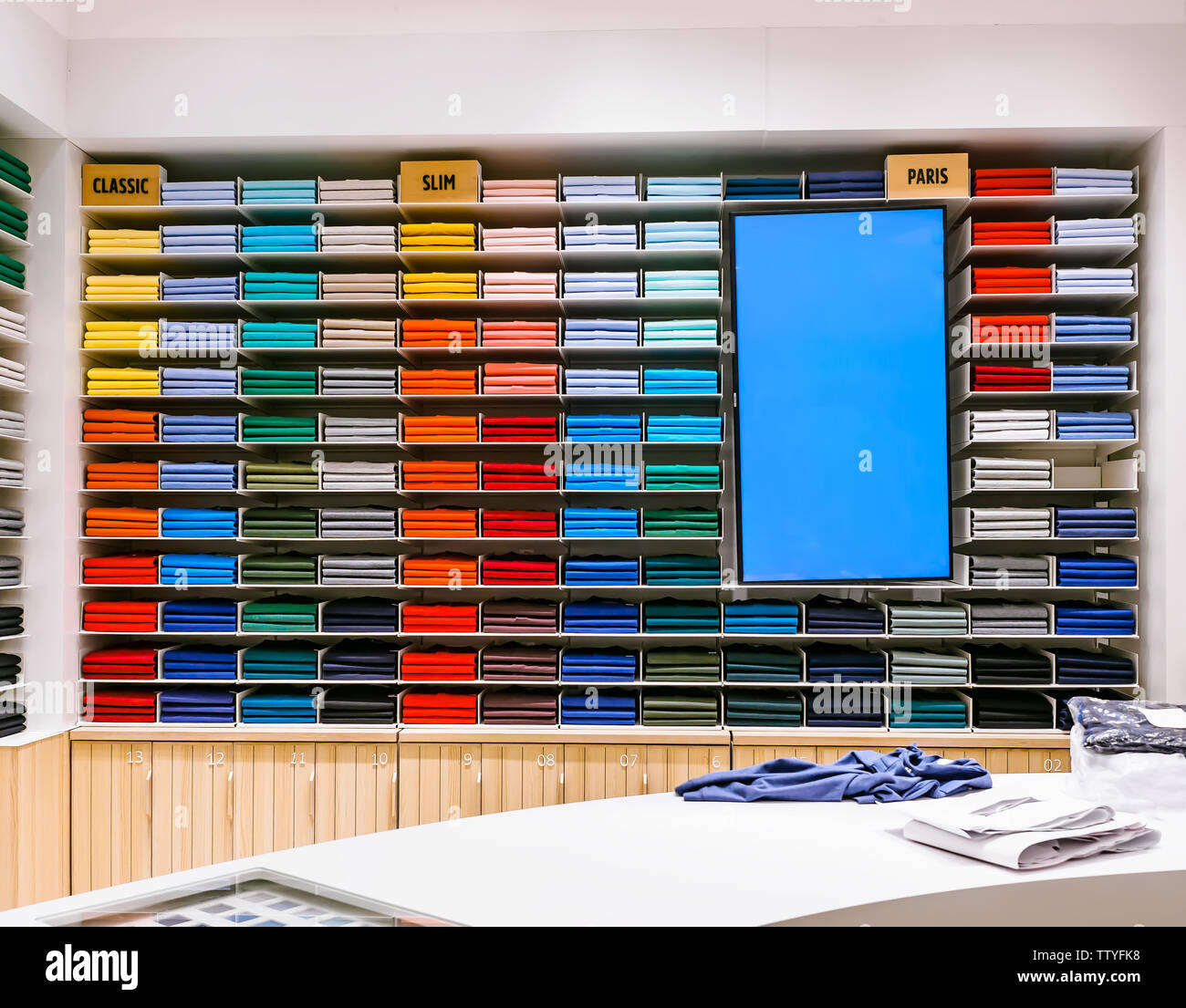 Rainbow colorida ropa background .varios colores vibrantes camisas  perfectamente plegados en un estante en la tienda. Indumentaria masculina  aparece coloreada en la tienda. T Fotografía de stock - Alamy