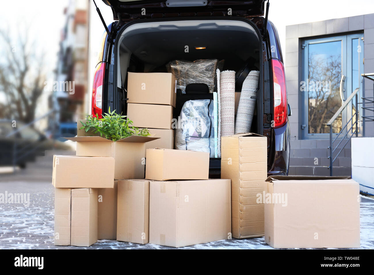 Cajas de cartón con cosas en el maletero del coche en el almacén Fotografía  de stock - Alamy