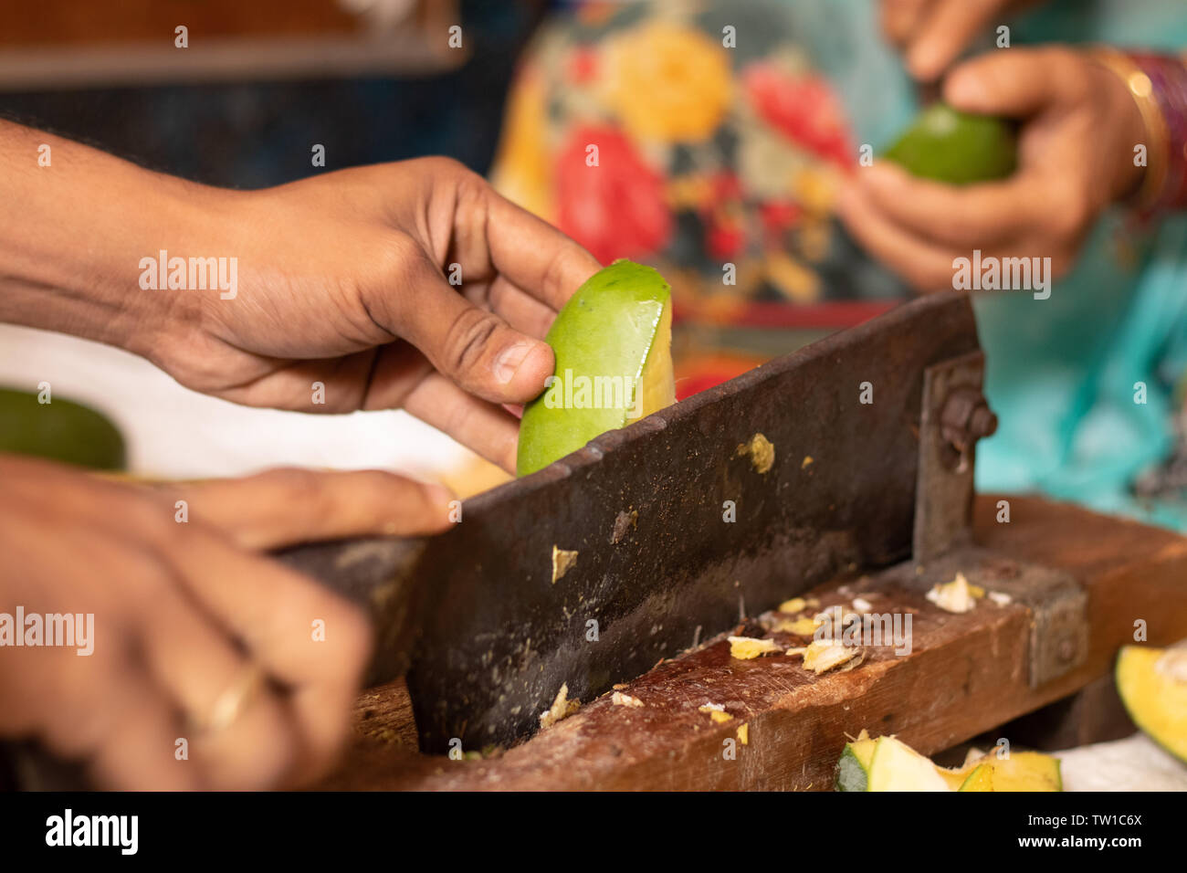 https://c8.alamy.com/compes/tw1c6x/entrega-closeuof-cortando-mango-maduro-para-hacer-picke-al-indio-en-la-india-con-la-cortadora-de-verduras-tw1c6x.jpg