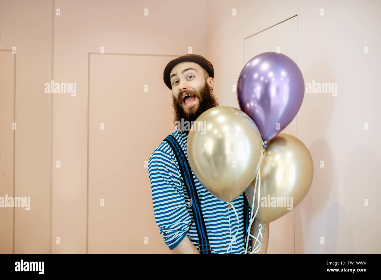 Retrato de un hombre alegre en ropa festiva con globos Coming Home para  fiesta de cumpleaños Fotografía de stock - Alamy