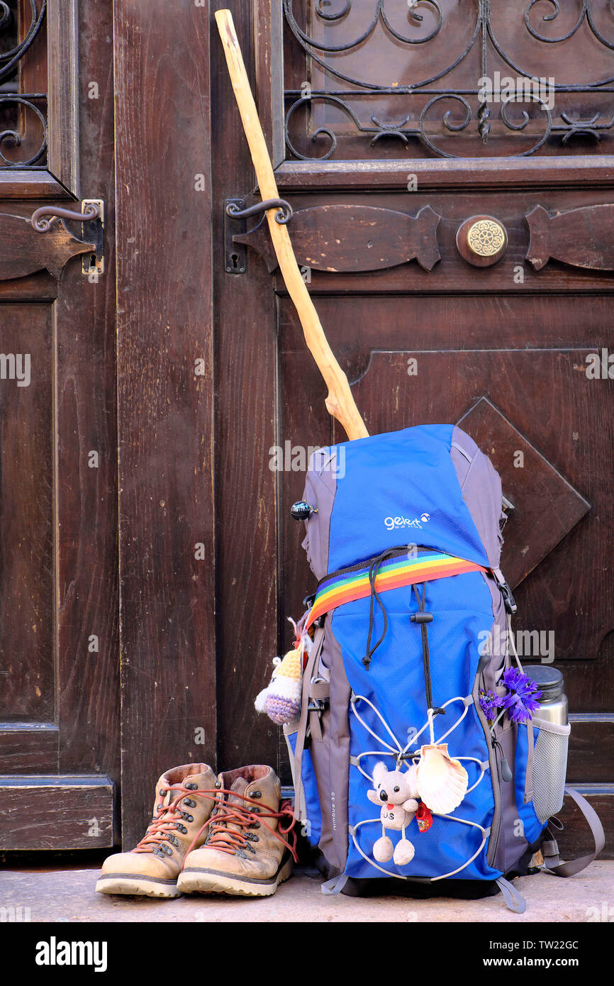 La mochila del peregrino en el Camino de Santiago, contra una puerta, en  Saint-Jean-Pied-de-Port (suroeste de Francia). Mochila, zapatos de  trekking, vieiras y pilg Fotografía de stock - Alamy
