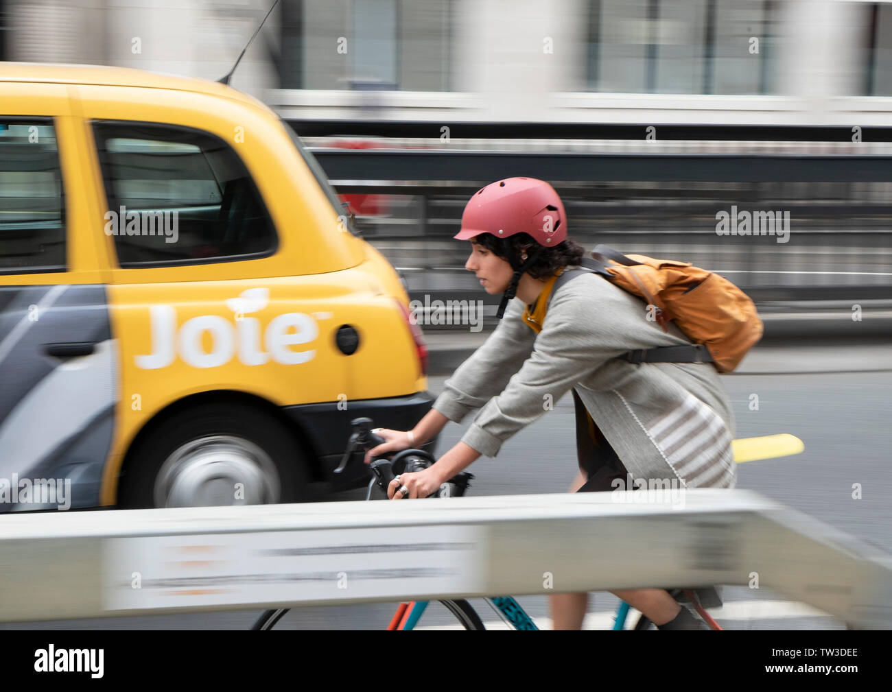 Desenfoque de movimiento captura de una hembra ciclista entrando en Waterloo Bridge, Londres Foto de stock