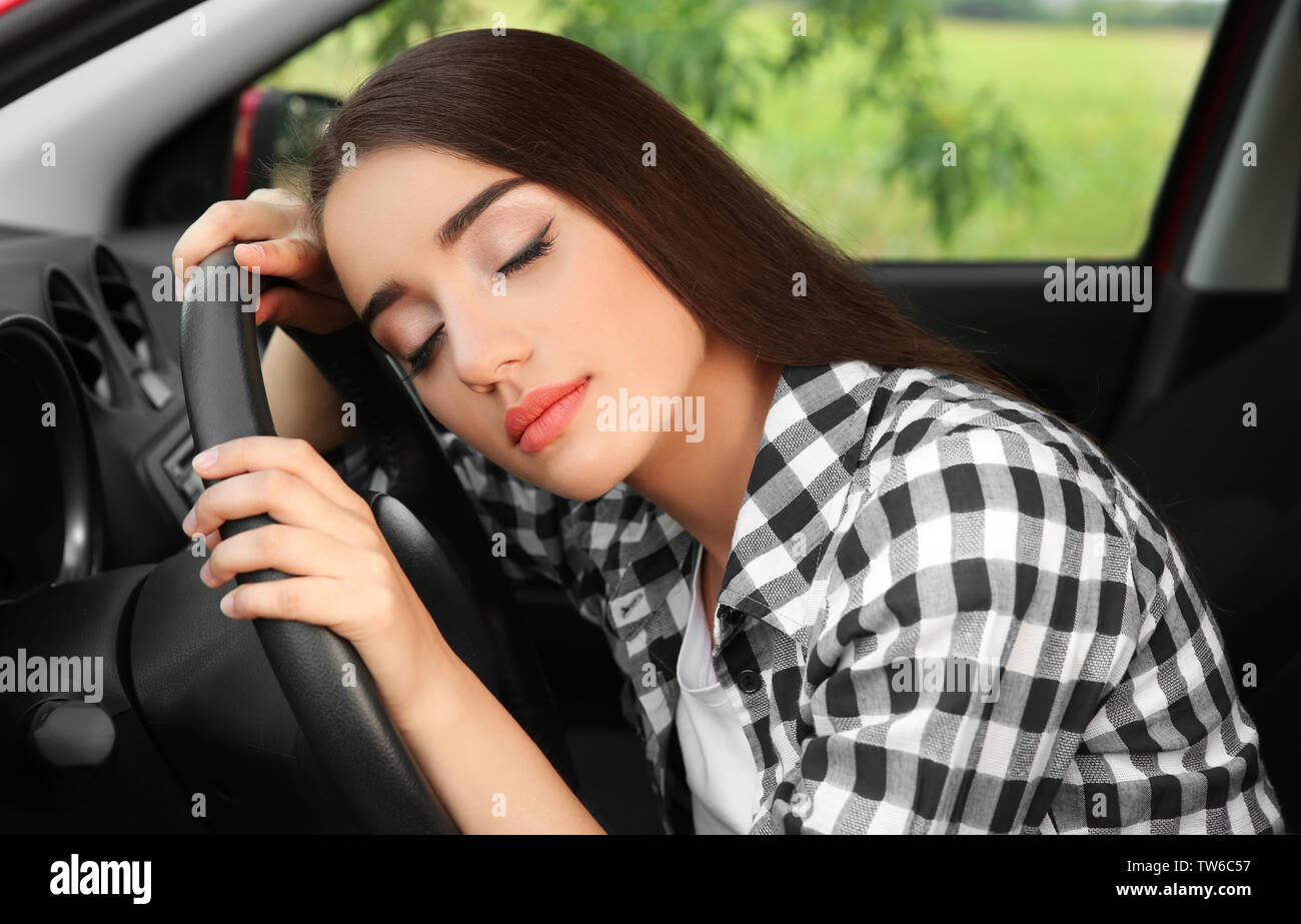 Mujer joven durmiendo en el coche Foto de stock