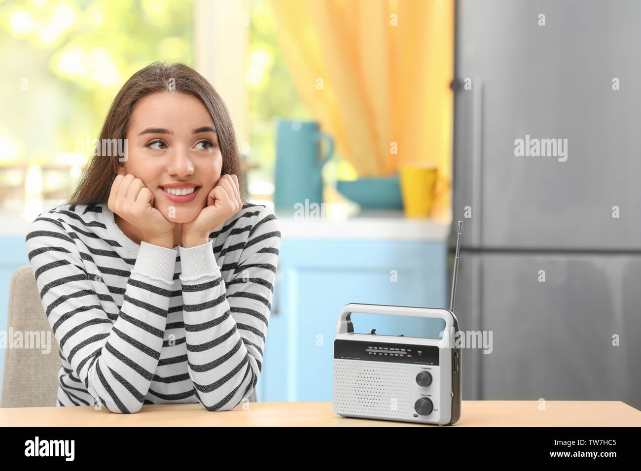 Mujer joven escuchando la radio en la cocina Fotografía de stock - Alamy