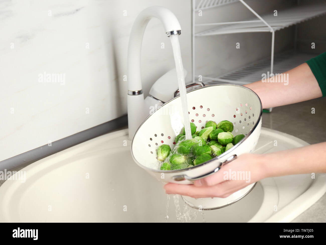 Mujer lava materias coles de Bruselas en el lavabo de la cocina Fotografía  de stock - Alamy