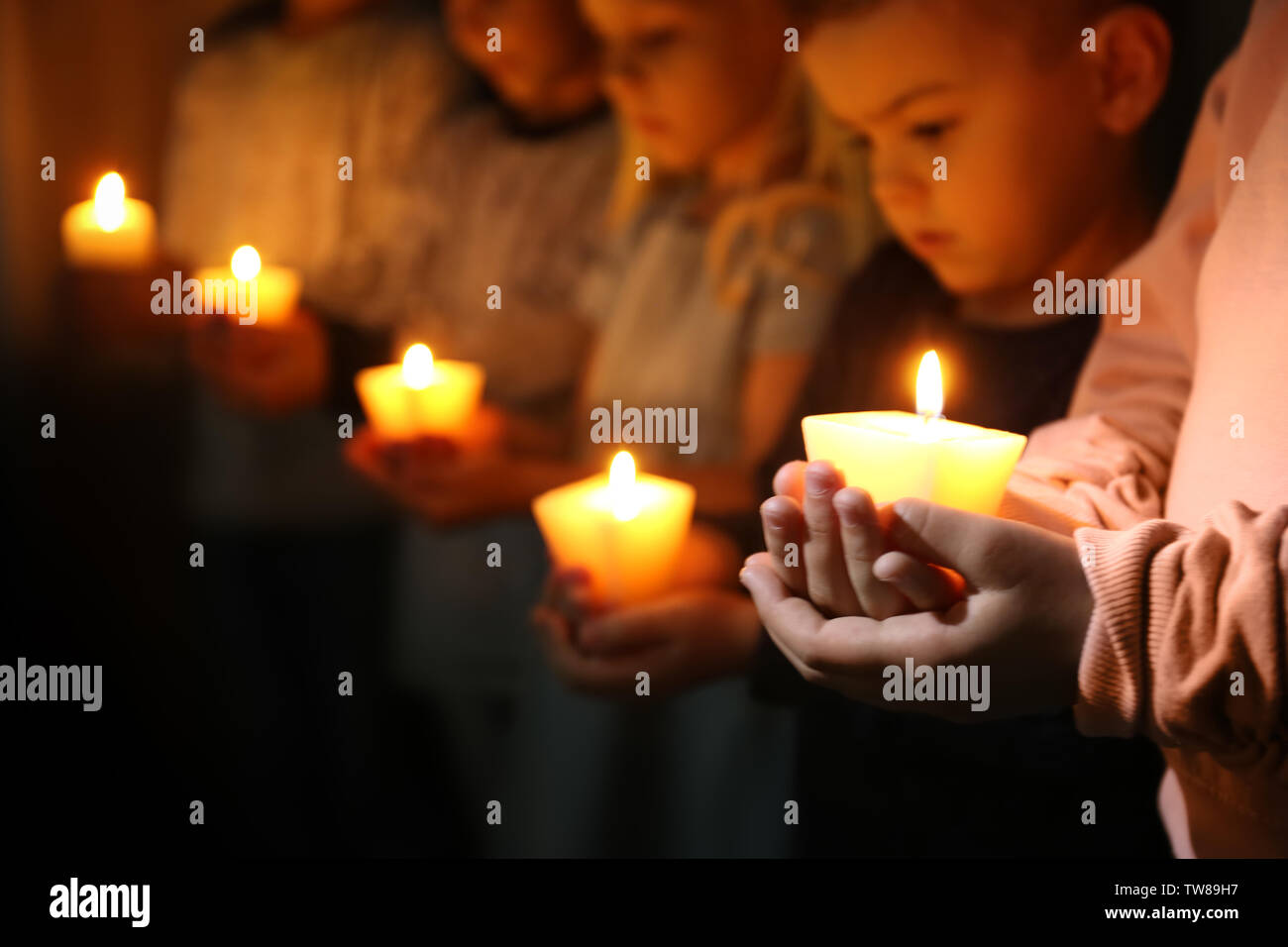 Los niños pequeños la celebración de las velas encendidas en la oscuridad  Fotografía de stock - Alamy