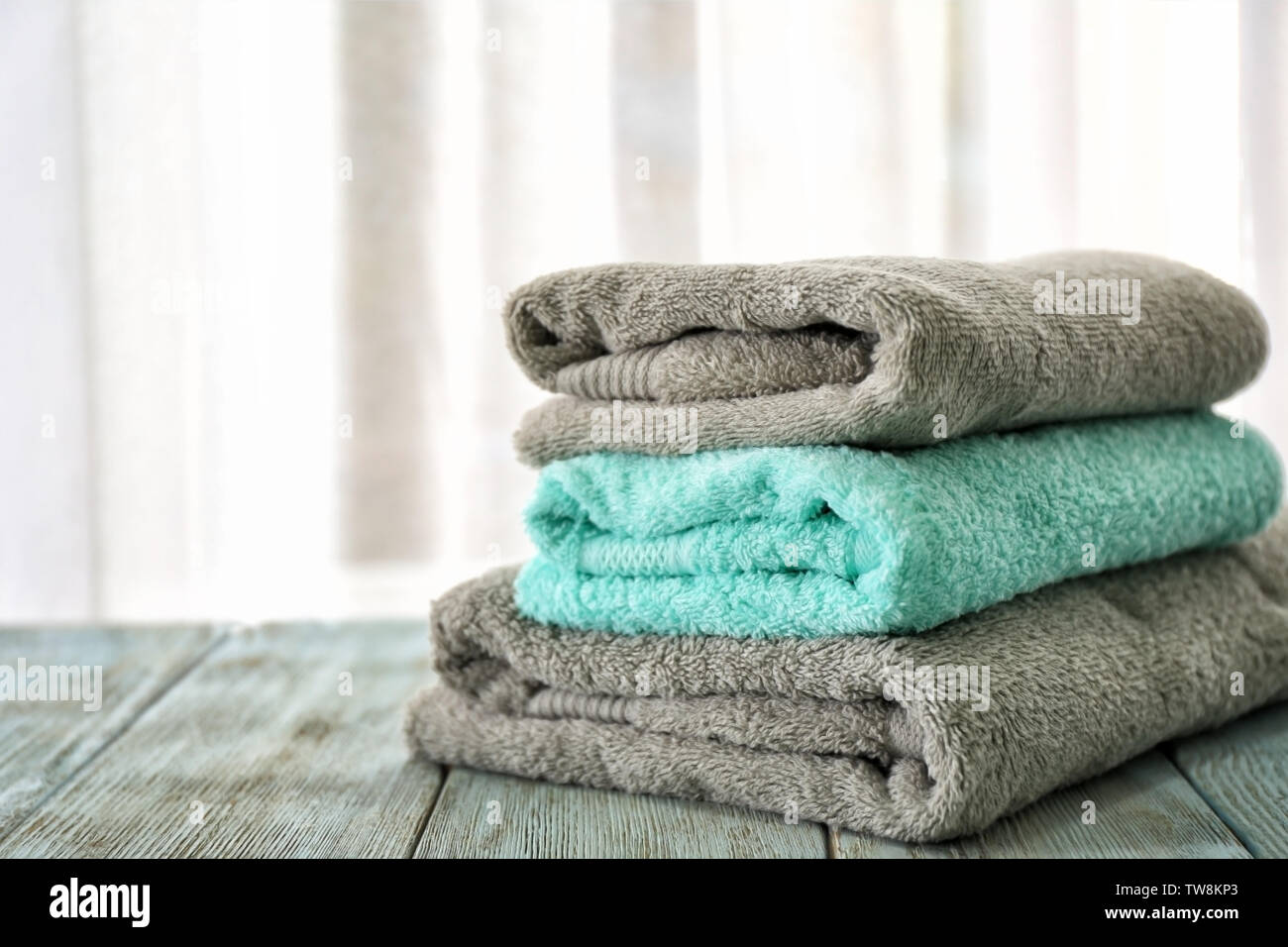 Pila de toallas de baño en la tabla contra la luz de fondo Fotografía de  stock - Alamy