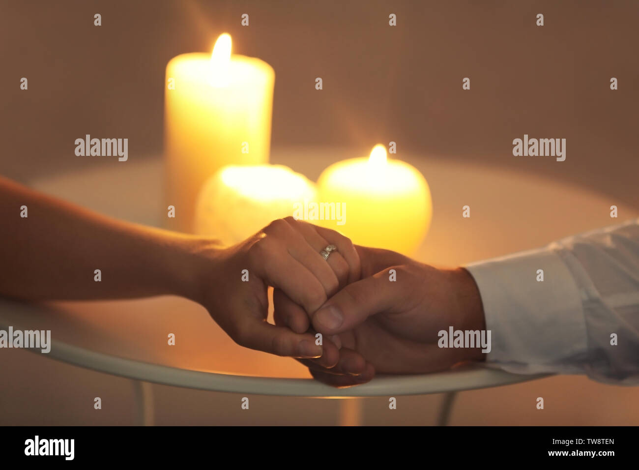 Pareja joven manos a la mesa con las velas encendidas Fotografía de stock - Alamy Pareja joven manos a la mesa con las velas encendidas Fotografía de stock - Alamy