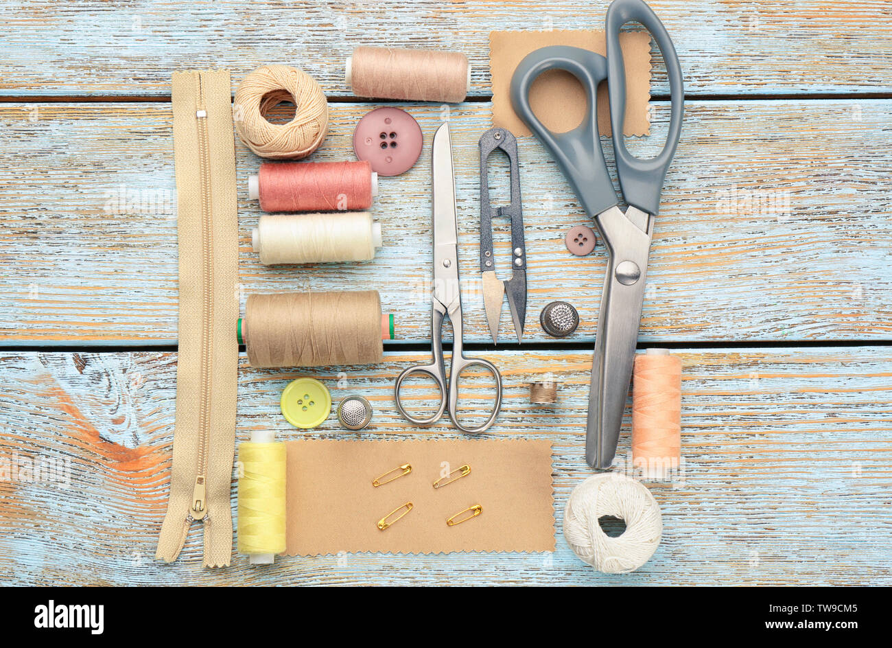 Hilos de colores y accesorios de costura sobre fondo de madera Foto de stock