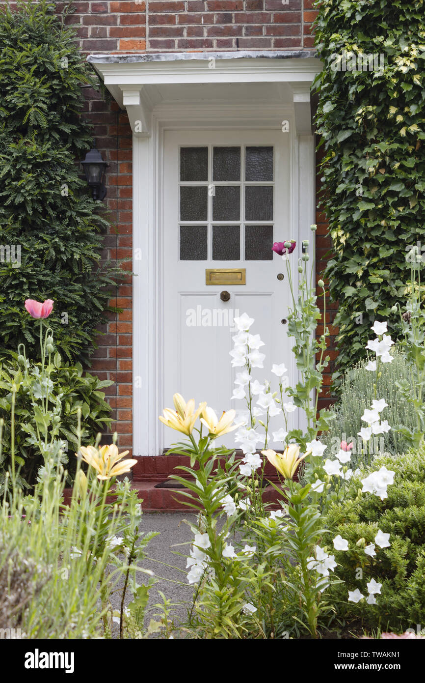 Mitad de madera barnizada con puerta frontal de un periodo House de Londres con un atractivo jardín de flores Foto de stock