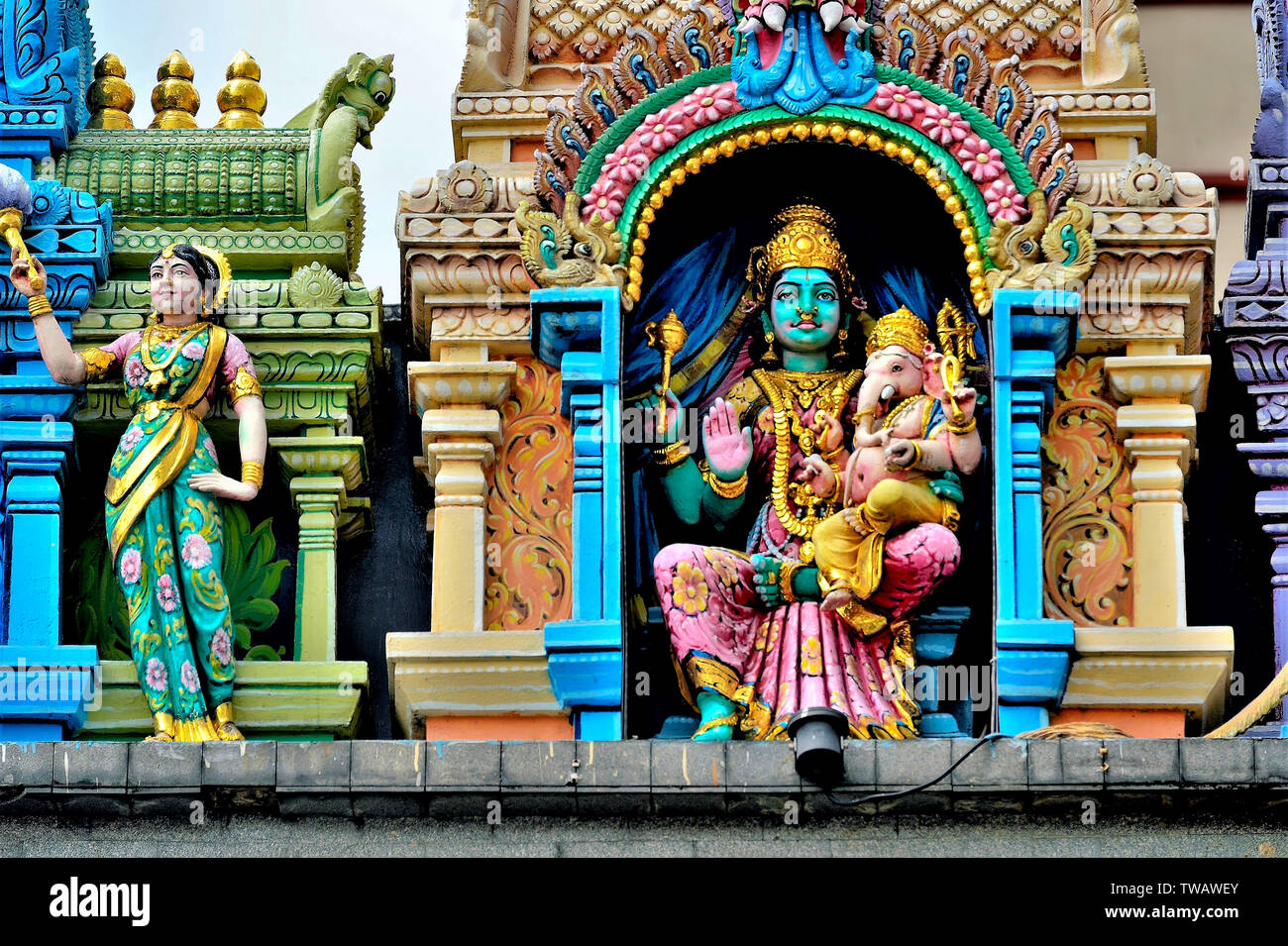 Coloridas estatuas de deidades religiosas hindúes que adornan la entrada del famoso templo hindú en Little India, Singapur en cerrar Foto de stock