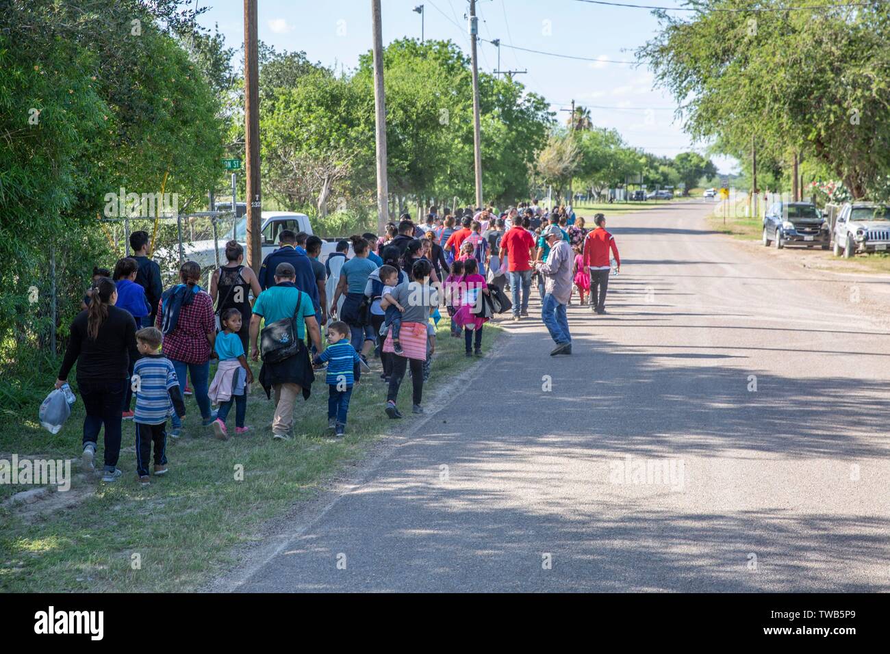 Un numeroso grupo de migrantes centroamericanos que buscan asilo, caminar hacia la ciudad a entregarse a la oficina de aduanas y la Patrulla Fronteriza el 15 de junio de 2019 en Los Ebanos, Texas. El grupo asciende a más de 100 familias, voluntariamente se entregaron a la Patrulla Fronteriza, después de cruzar la frontera ilegalmente con la esperanza de obtener asilo. Foto de stock
