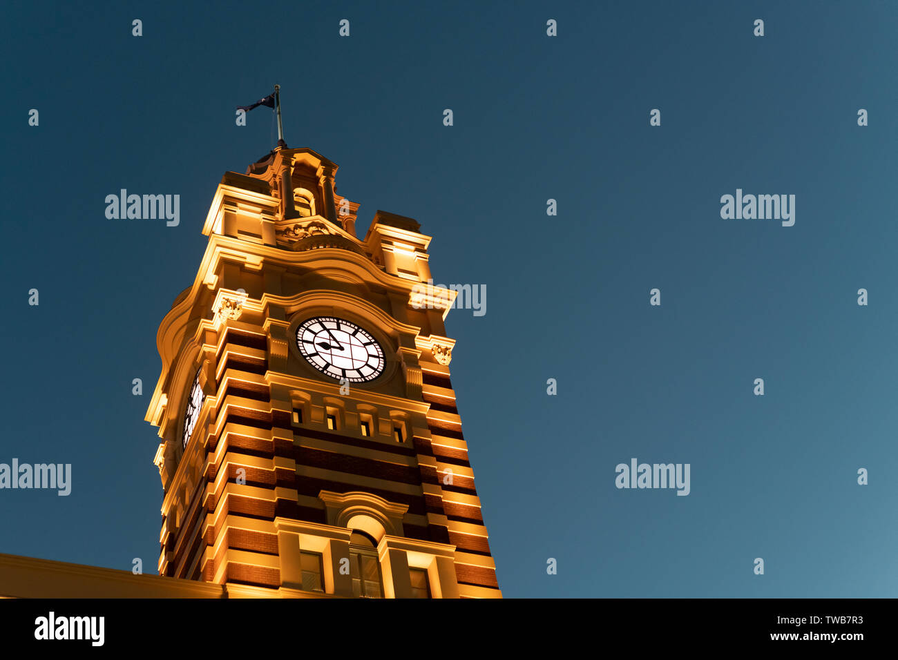 La torre del reloj de la estación de tren de Flinders Street al anochecer. Foto de stock