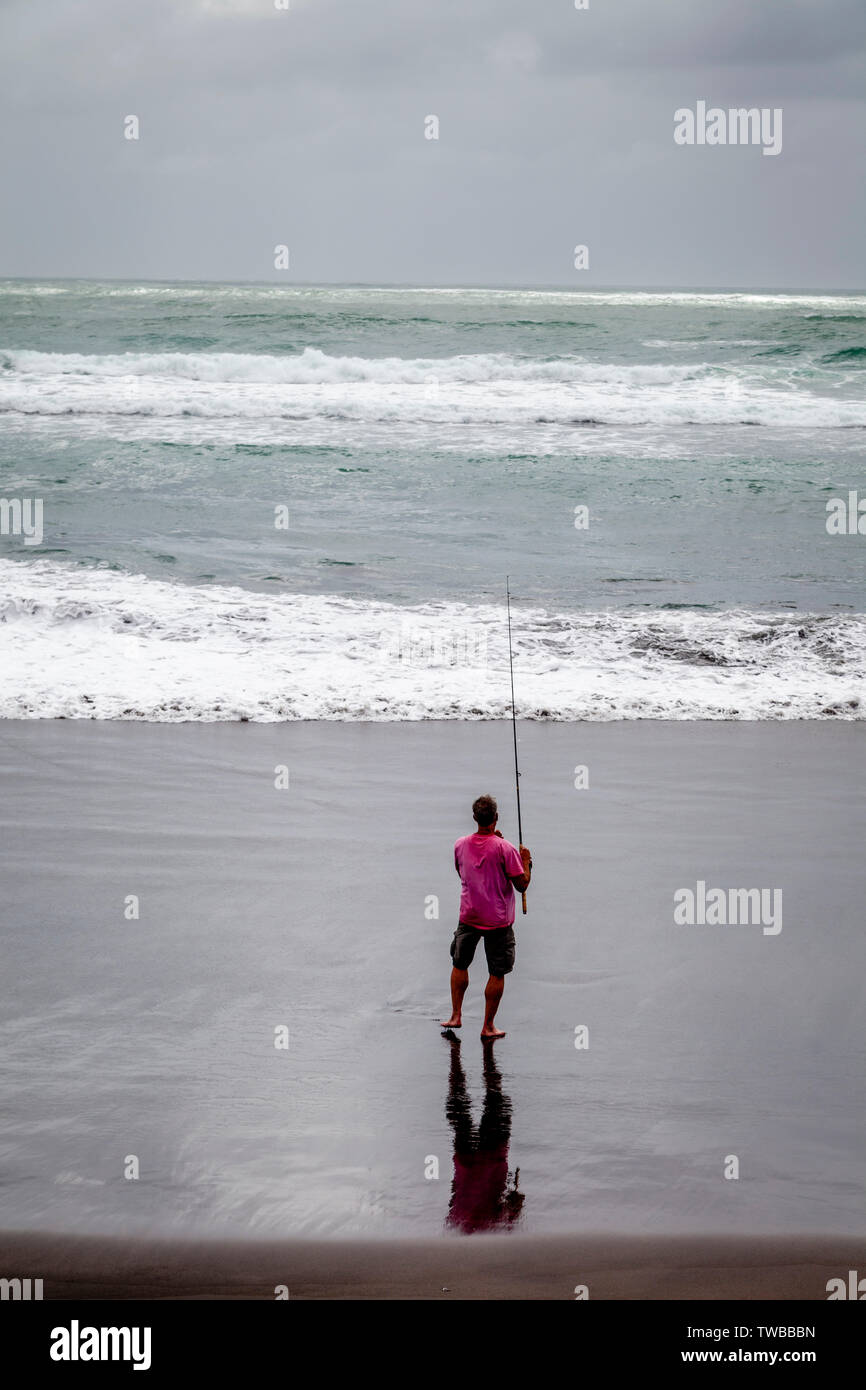 Un pescador en la playa de agua caliente (Ocean Beach), Kawhia, Isla del Norte, Nueva Zelanda Foto de stock