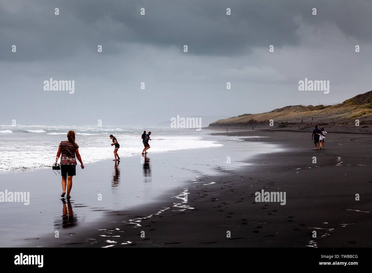 Un grupo de personas caminando por la playa de agua caliente (Ocean Beach), Kawhia, Isla del Norte, Nueva Zelanda Foto de stock