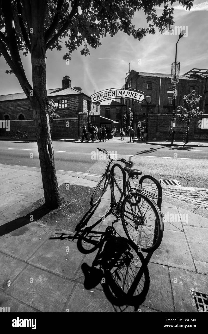 Bicicleta aparcado al sol cayendo al suelo sombra,fuera de Camden Market Londres Foto de stock