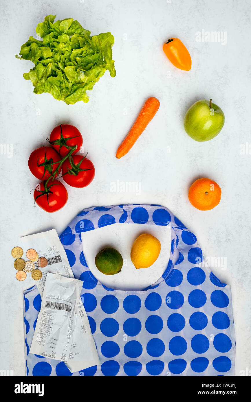 Still life de compras con verduras, una bolsa, el billete y el cambio en la tabla Foto de stock
